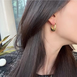 Orecchini a cerchio a U in oro lucido per donna mostrati su modella per uno stile elegante