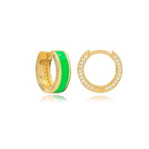 Macro-opname van gouden oorringen met groen emaille en diamanten accenten aan de zijkant