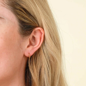 Piccoli orecchini a cerchio dorati minimalisti da donna con finitura lucida di lusso