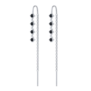 Dettaglio di orecchini pendenti in argento con pietre nere sfaccettate e piccole lune