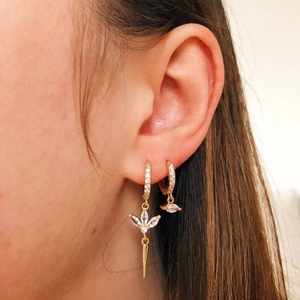 Detail showing gold earrings with marquise cubic zirconia and tapered cone pendants on model