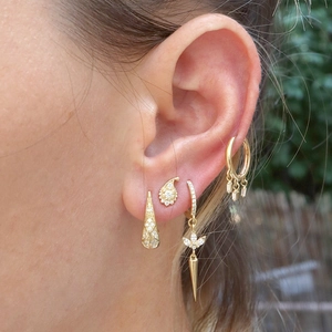 Macro shot of gold-plated multi-earring set featuring paisley and tassel charms