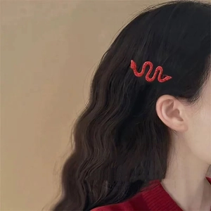 Elegant red snake hair clip with crystals worn by a model for a festive hair style