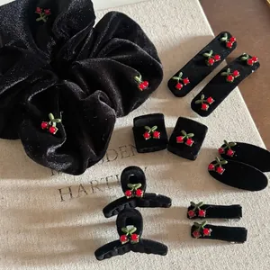 Retro black velvet hair accessory set featuring red cherry charms on scrunchie and clips
