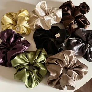 Glossy large satin scrunchies in eight colors with handmade label on white background