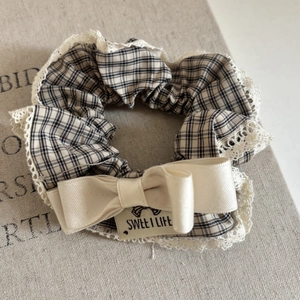 Detailed view of checkered scrunchie with lace edge and sweet life bow ornament