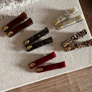 Chic acetate hair clip set in assorted marble and leopard patterns with gold love emblem