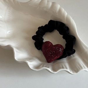 Elastico per capelli nero in tessuto con cuore di strass rossi su vassoio a conchiglia