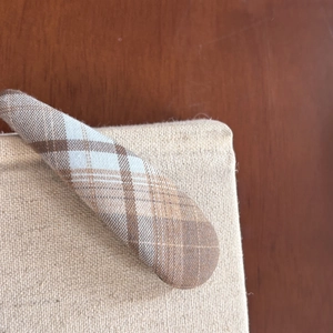 Detailed view of the sea salt blue plaid fabric texture on a long oval hair clip