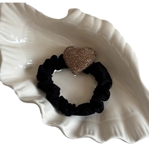 Elegante elastico per capelli nero con grande ciondolo a cuore in strass su un piatto