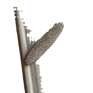 Barrette ovale étincelante avec finition argentée et strass pavés sur du tissu