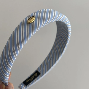 Detailansicht vom blau-weiß karierten Polster-Haarreif mit goldener Metallschnalle