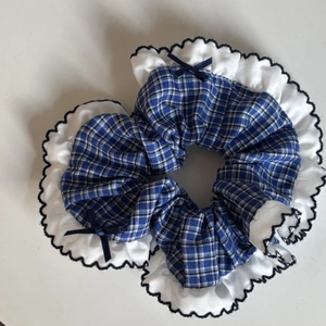 Navy blue plaid scrunchie with white lace trim and delicate ribbon bow accessory