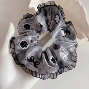 Chouchou élégant en dentelle grise avec motifs de pattes de chat et nœud brodé