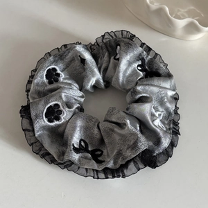 Détail du chouchou en soie argentée avec dentelle organza noire et broderie chat