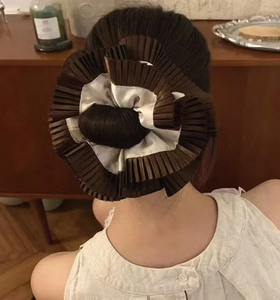 Detailed back view of a pleated brown and cream scrunchie worn on a hair bun