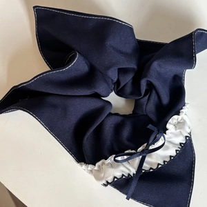 Detail of navy blue hair scrunchie with rabbit ear bow and white contrast stitching