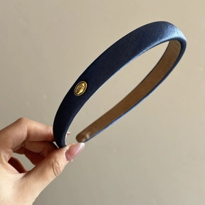 Detail of navy blue textured fabric headband with gold love buckle and non-slip lining