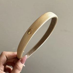 Detail of champagne satin headband with gold oval metal plate and love engraving