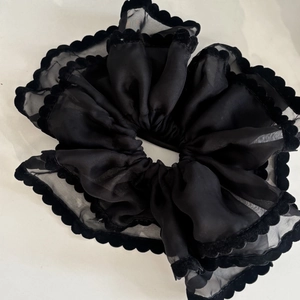 Detail view of large black double-layer lace scrunchie with scalloped velvet trim