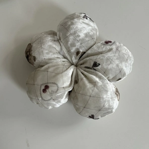 Chouchou en peluche beige avec motif à carreaux gris et imprimés de cerises rouges