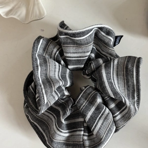 Vintage black and white striped scrunchie with fashion tag on a minimalist background