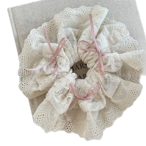 Elegant off-white lace scrunchie with floral embroidery and small pink ribbon bows