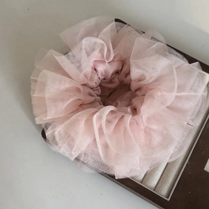 Elegant pink lace organza scrunchie hair tie for women on a display case