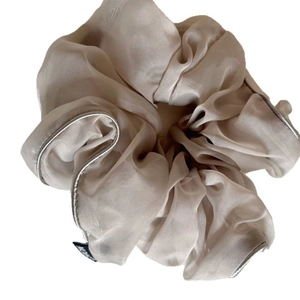 Elegant champagne organza scrunchie with silver stitching on a white background