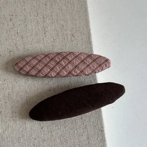 Detail view of pink plaid and brown fabric BB hair clips for girls in a two-piece set