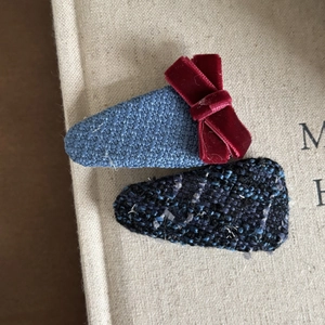 Close-up of woven fabric BB hair clips with red velvet bow and tweed texture for girls