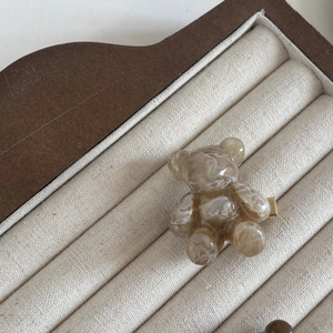Pince à cheveux ours mignon en écaille de tortue brune sur présentoir en velours beige