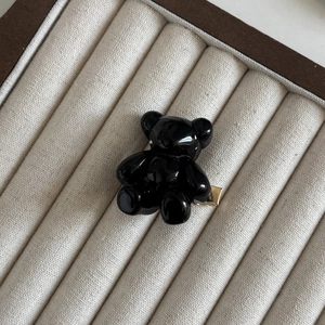 Détail d'une mignonne pince à cheveux ours noir brillant avec base dorée pour la coiffure