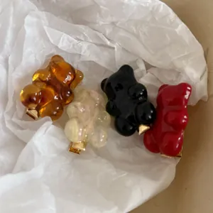 Détail de quatre barrettes oursons en résine colorée avec clips métalliques dorés