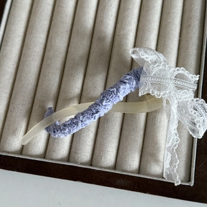 Elegante fermaglio per capelli in pizzo viola con fiocco color crema su vassoio in velluto