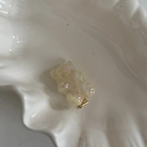 Barrette ours ambre translucide avec paillettes roses sur plateau en céramique blanche