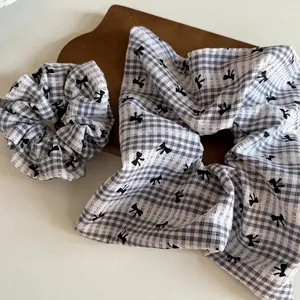 Ensemble de chouchous faits main à carreaux avec nœud papillon sur plateau bois
