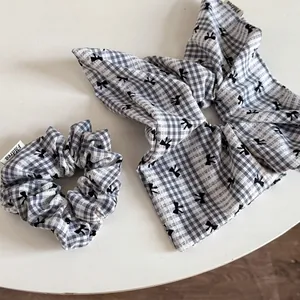 Détail d'un ensemble de chouchous à carreaux noirs et blancs avec ruban et nœud