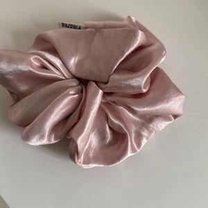 Pink cream satin silk scrunchie with soft glossy finish and brand logo label