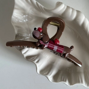 Detailopname van schattige teckel haarklem in een schelpschaal met rood appeldetail