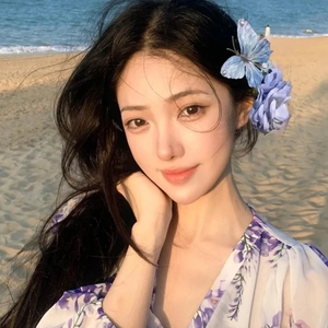 Elegante fermaglio per capelli a farfalla blu su modella in spiaggia con abito a fiori