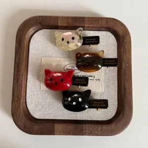 Lot de quatre barrettes à cheveux en acétate en forme de chat en rouge, noir et ambre