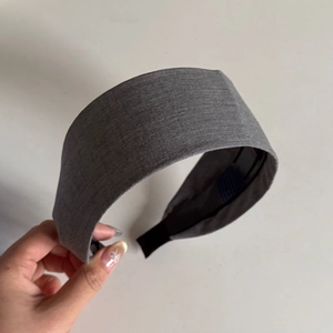 Detail view of dark grey wide headband with textured fabric and black non-slip inner lining