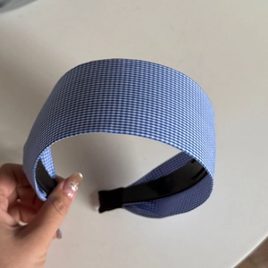 Detailed view of the blue and white gingham fabric texture on the wide-brim headband