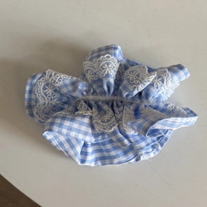 Detailed view of blue and white checkered scrunchie with delicate floral lace trim
