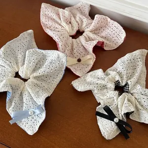 Lot de chouchous à nœuds en dentelle avec perles et carreaux sur fond de bois