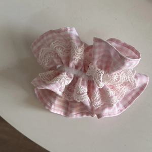 Detailed view of pink plaid hair scrunchie featuring white lace trim and elastic ruffles