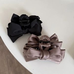 Elegant satin bow hair claw clips in black and taupe shown in a 45-degree layout