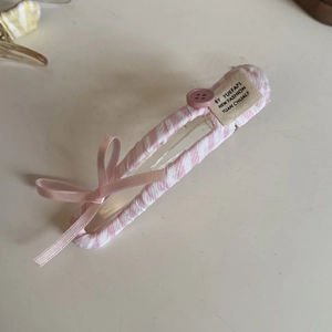 Detail of pink plaid hair clip with silk bow, decorative button and textile label