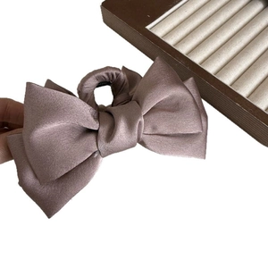 Elegant dusty pink satin bow hair claw clip with a glossy finish for women's hairstyling